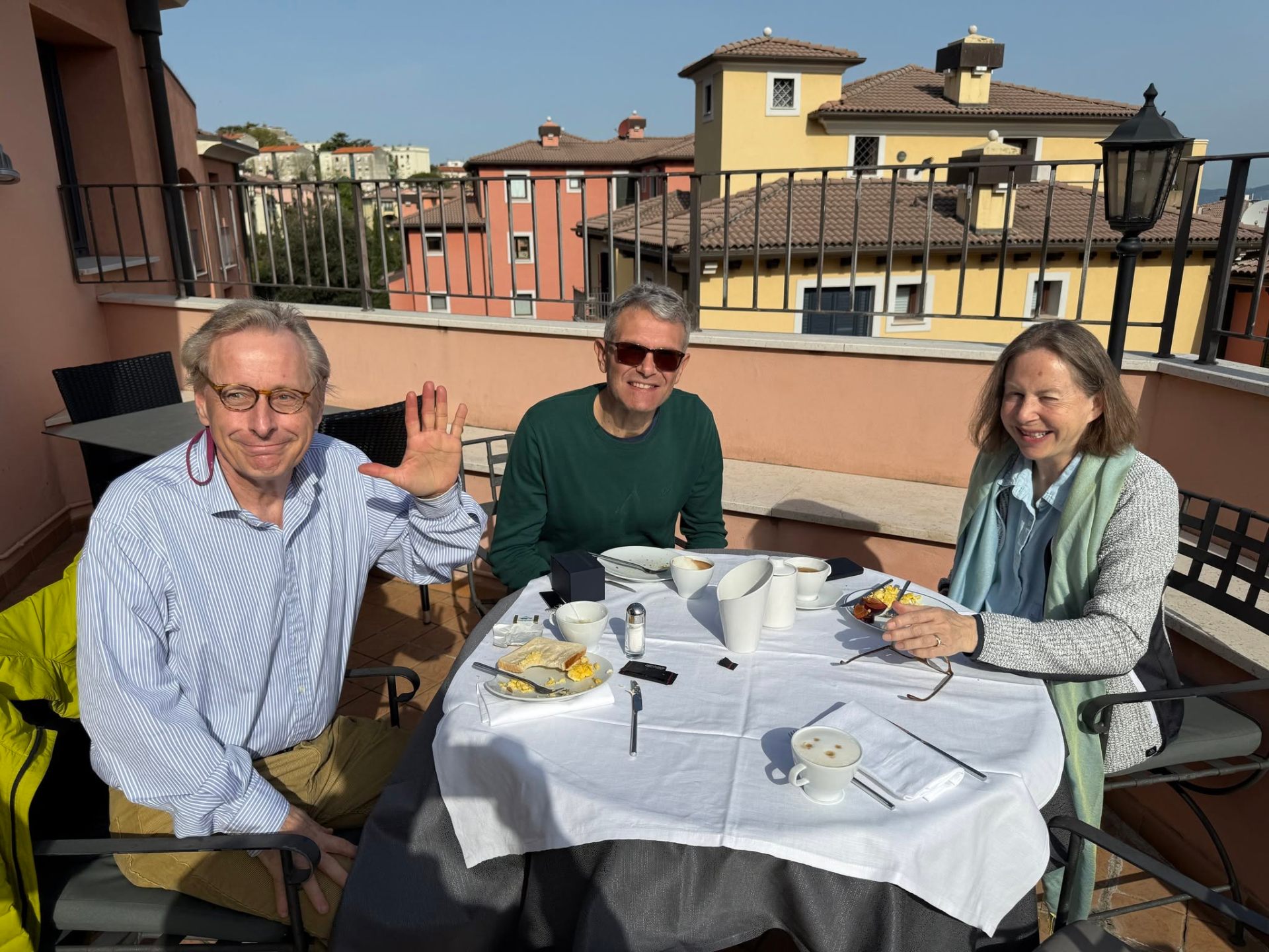 Pierre at a sunny rooftop breakfast in Italy with two friends.